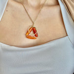 Necklace with a triangular pendant worn by a person