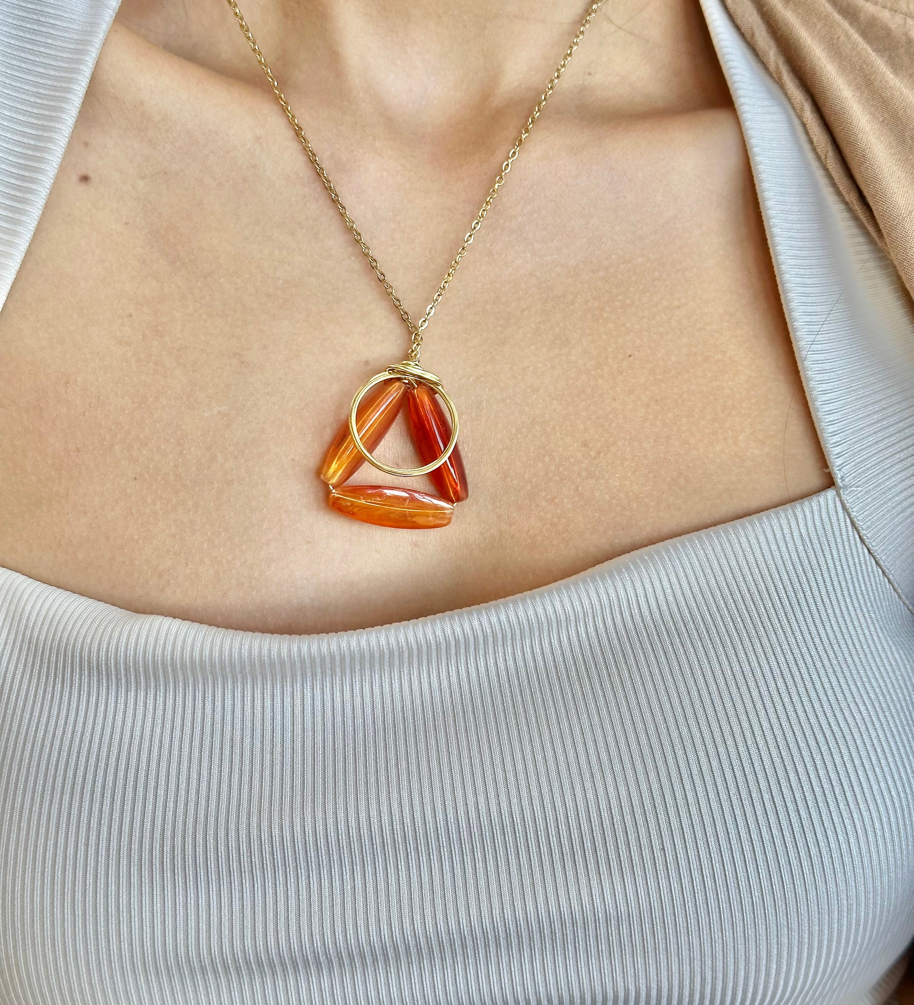Necklace with a triangular pendant worn by a person